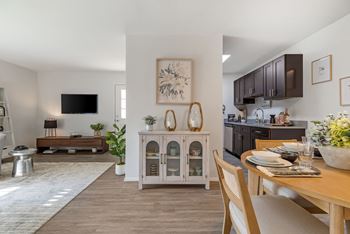 A modern dining room with a wooden table and chairs.